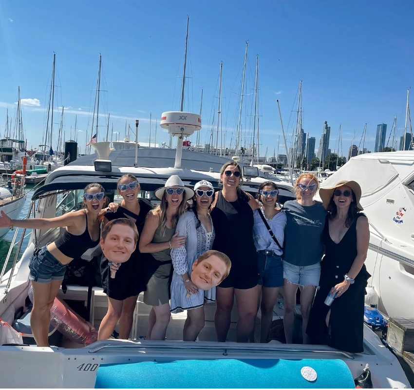 Friends posing for a group photo on a private birthday boat rental in Chicago at the marina.