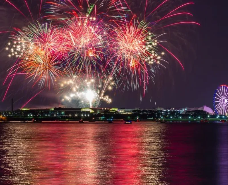Chicago fireworks cruise near Navy Pier with colorful fireworks reflecting on Lake Michigan.