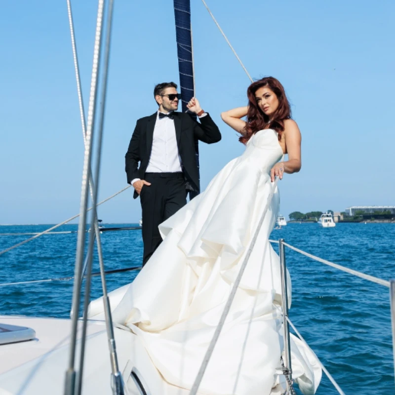 A couple in formal wedding attire celebrating on a luxury sailboat rental in Chicago.