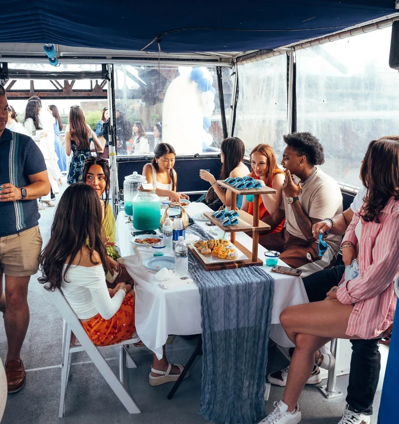 Guests enjoying food and drinks onboard a private boat rented for a birthday party in Chicago.