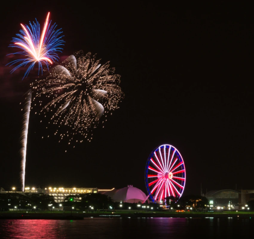 Navy Pier fireworks over Lake Michigan with the Centennial Wheel—view from a private boat charter in Chicago