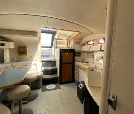 Spacious luxury yacht interior with seating, kitchenette, and refrigerator on a private Chicago yacht charter